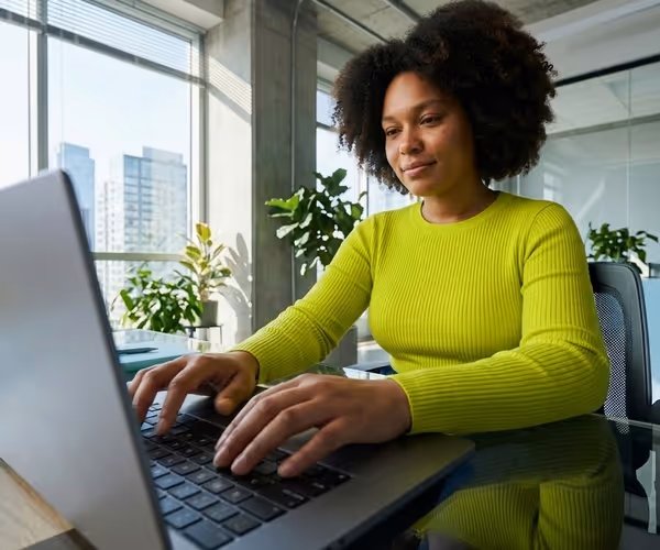Een vrouw zit achter haar laptop
