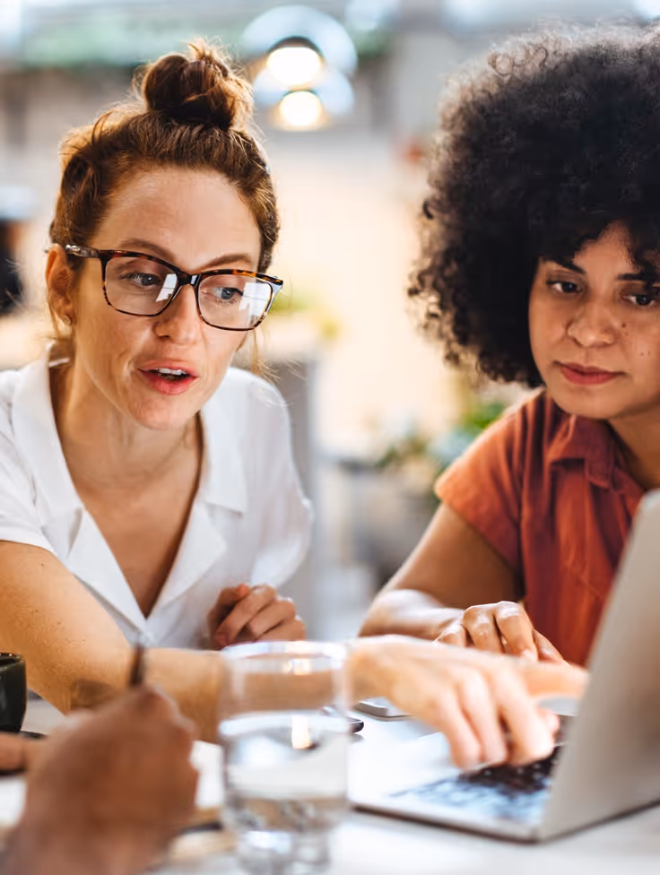 Twee vrouwen aan tafel met papieren