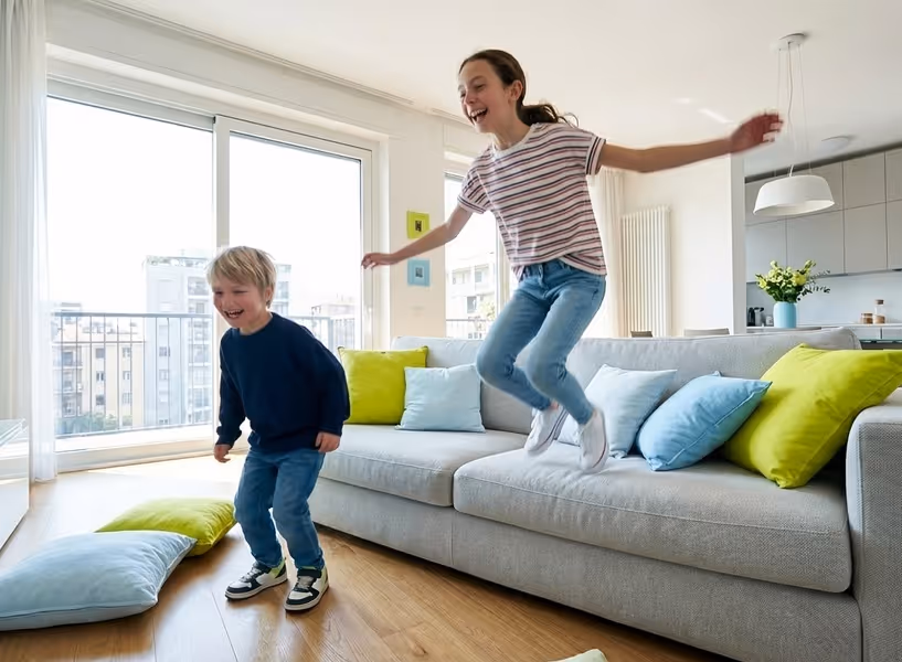 Twee kinderen springen van de bank in een woonkamer